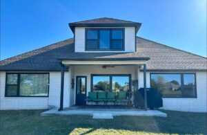 Sunny blue sky background with a White painted home with black windows